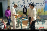 جهادگران دانش آموز بسیجی برادر در حال تعمیر میز و صندلی مدرسه