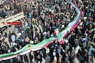 حمل پرچم ۶۰ متری توسط ورزشکاران با لباس&zwnj;های ورزشی در طول مسیر راهپیمایی شیراز
