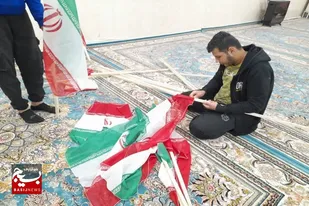 اهتزاز پرچم ایران اسلامی بر سر درب خانه در سرخه